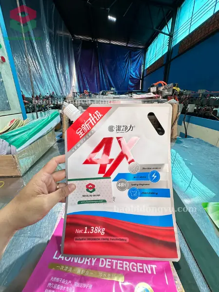 Túi có vòi đáy đứng đục quai xách in đỏ xanh đựng nước giặt, kẹp danh thiếp Đông Vũ trên sàn xưởng