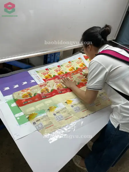 nhân viên của Đông Vũ kiểm tra kĩ màu sắc và kích thước của cuộn màng đóng gói tự động